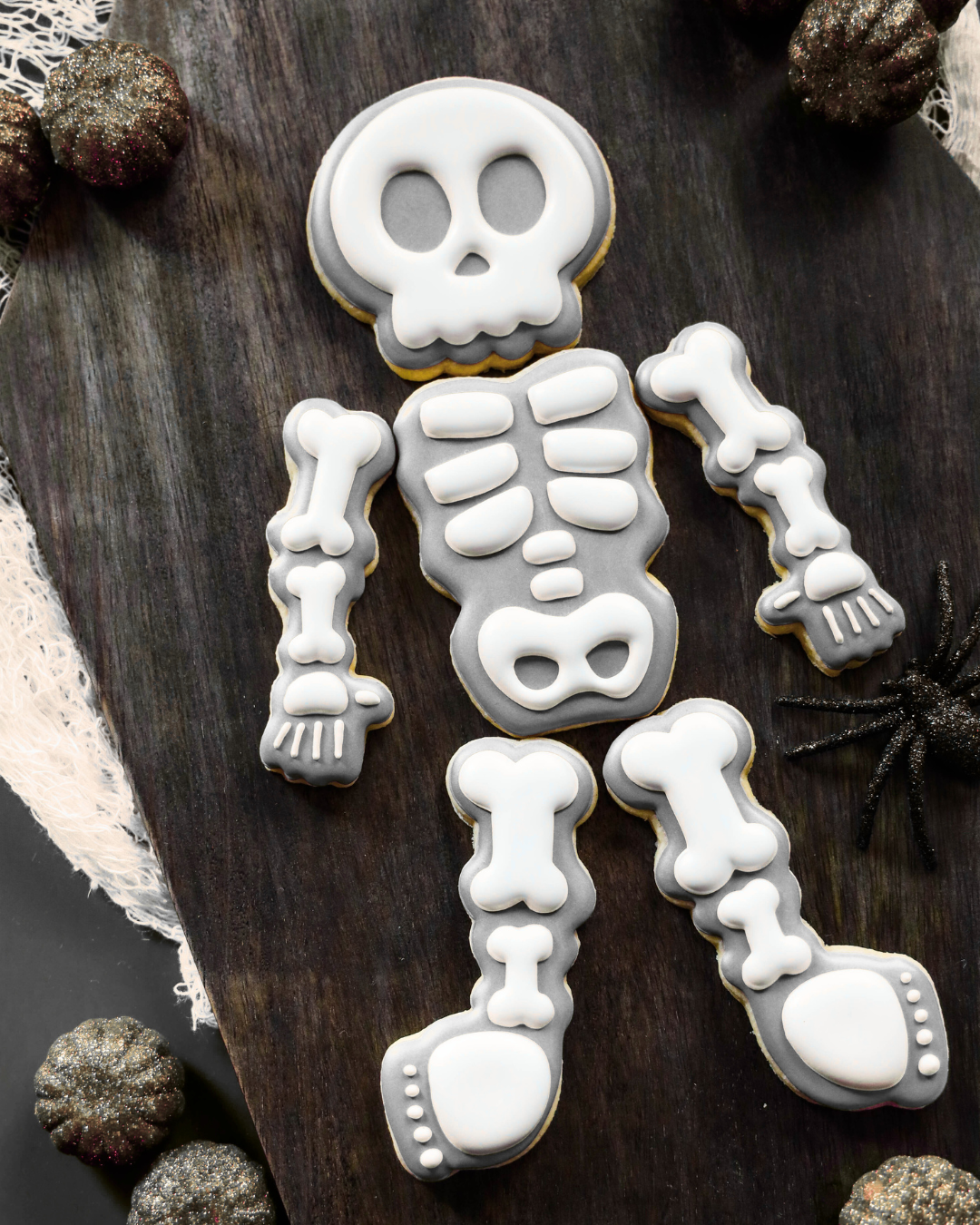 Skeleton cookie decoration on a wooden surface with decorative elements.
