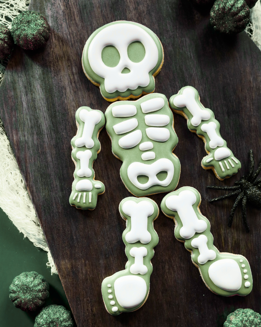 Skeleton cookie decoration on a wooden surface with green and white icing