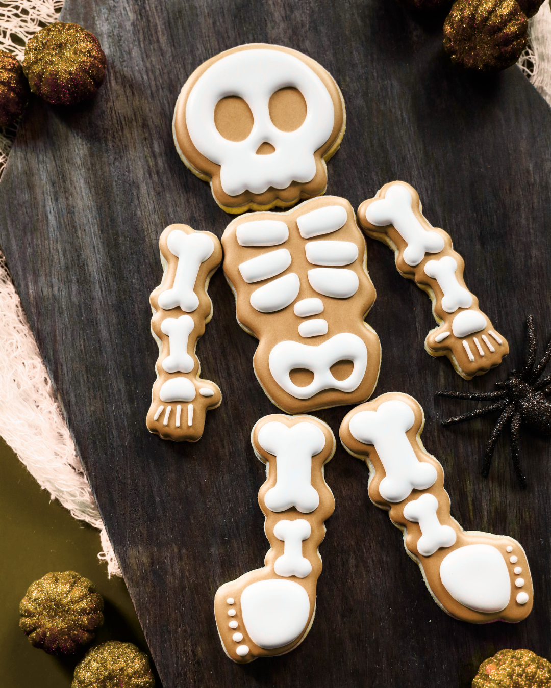 Skeleton cookie decoration on a wooden surface with decorative elements.