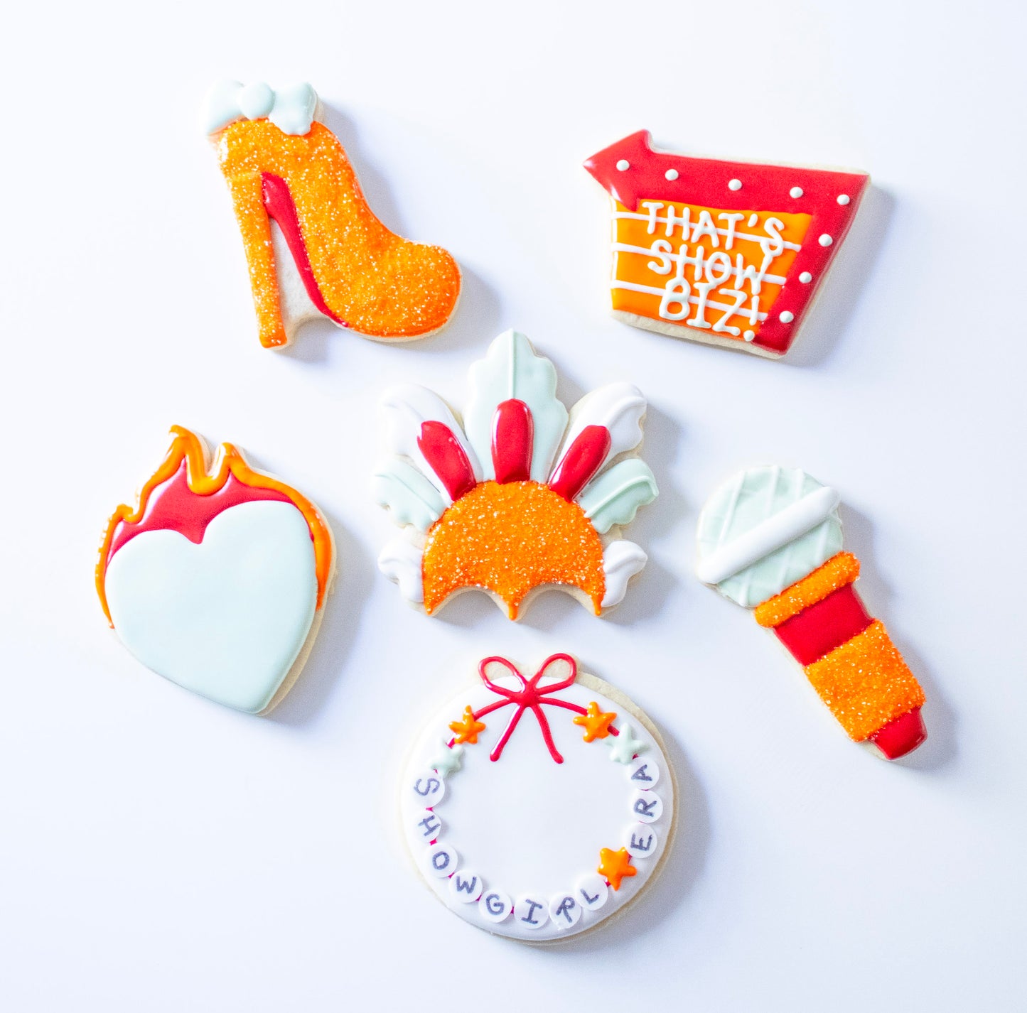 Decorative cookies shaped like a high heel, shopping cart, heart with flames, and other designs on a white background.