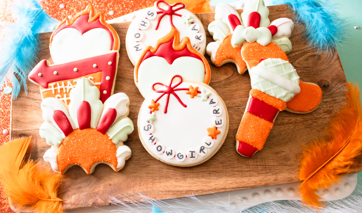 Decorative cookies shaped like a turkey, gift box, and other festive items on a wooden board.