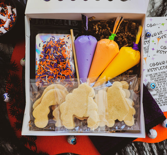 Cookie decorating kit with colorful cookie cutters and icing in a box.