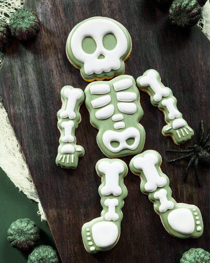 Skeleton cookie decoration on a wooden surface with green and white icing